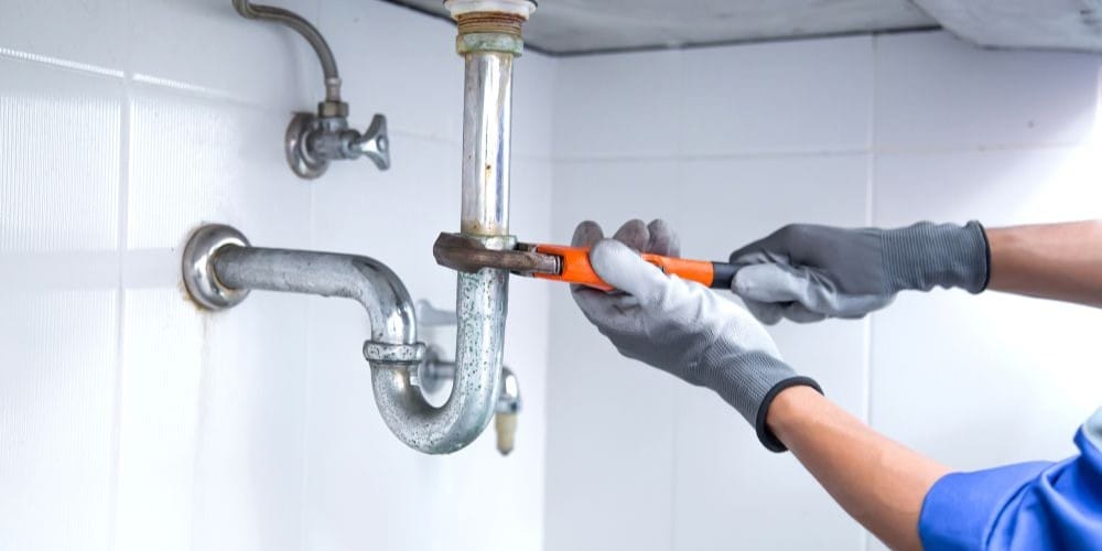 Plumber fixing a leaky pipe.