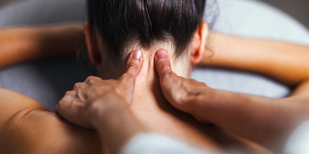 Woman receiving a neck massage at a massage studio.